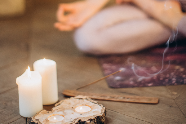 yogi sitting with candles & incense in front of them